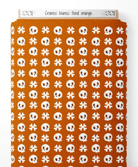 Tissu - Crânes blancs sur fond orange