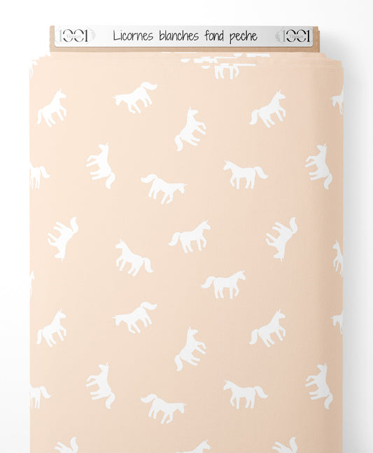 Tissu - Licornes blanches sur fond pêche