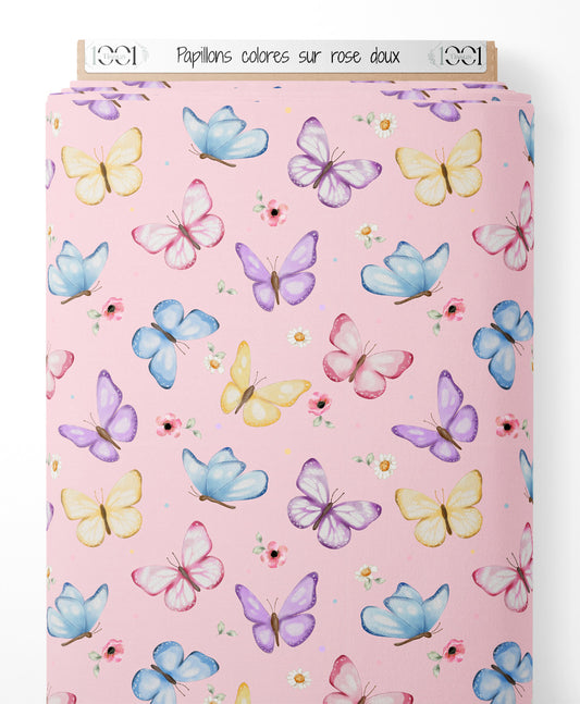 Tissu - Papillons colorés sur rose doux