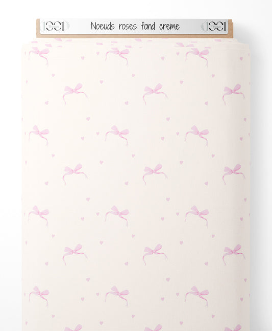 Tissu - Nœuds roses sur fond crème